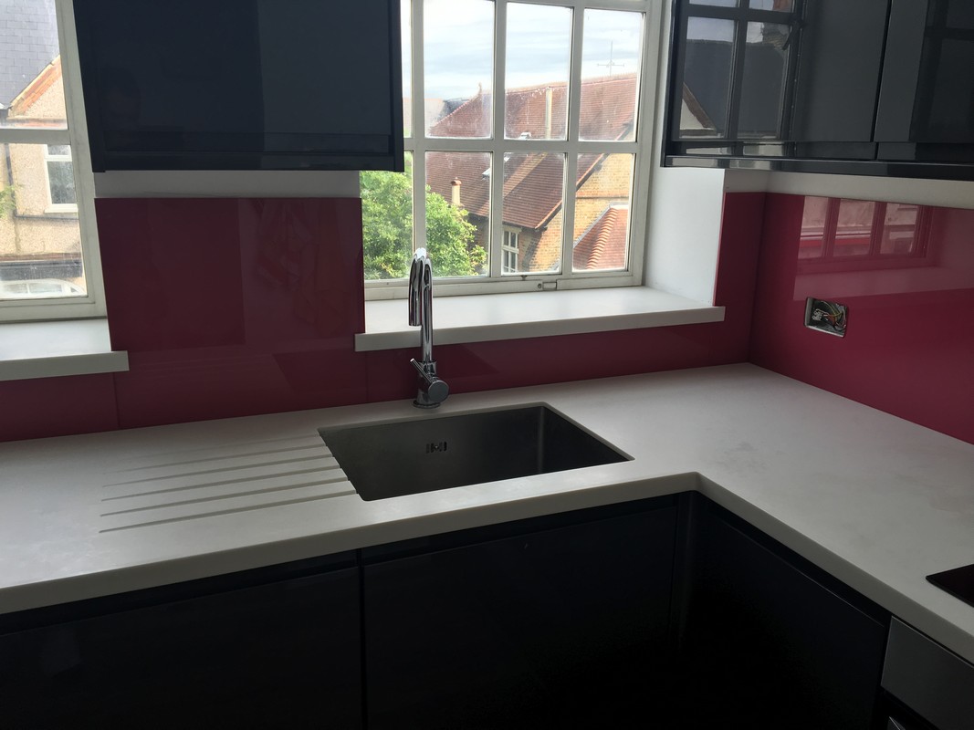 Deep plum coloured glass splashback in modern Regent's Park kitchen